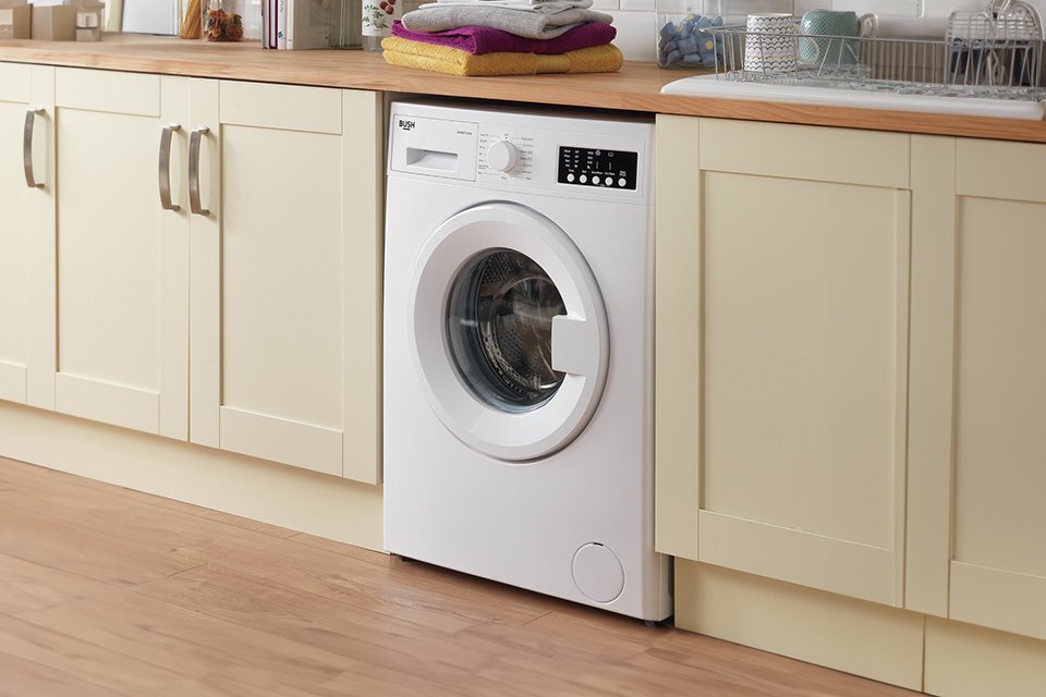 A Bush 7KG white washing machine in a utility room.