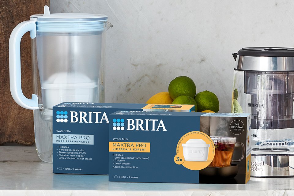 BRITA MAXTRA PRO filter cartridges next to other BRITA products on a kitchen countertop. 