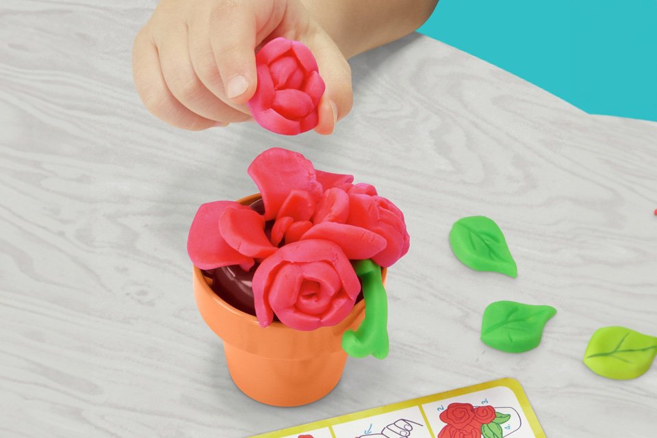 A child playing with Play-Doh Fantastical Flowers.