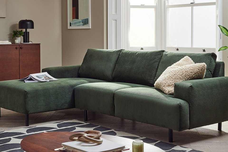 - A Habitat Julien Fabric Left Hand Corner Chaise green Sofa near a walnut sideboard.