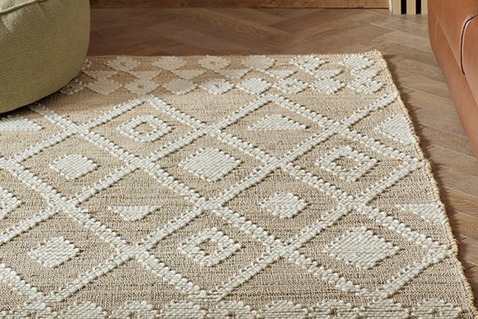 A Habitat Woven Aztec Neutral Jute Flatweave Rug in a room.