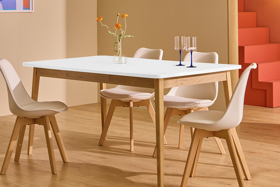 Two glasses on a Habitat Sylas Solid Wood 4 Seater White Dining Table in a dining room.