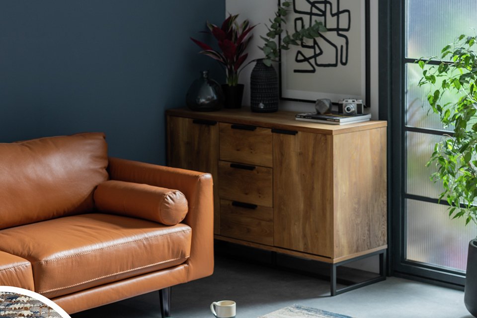 A Habitat Distressed Abstract Blue Flatweave Rug and a tan brown sofa in a living room.