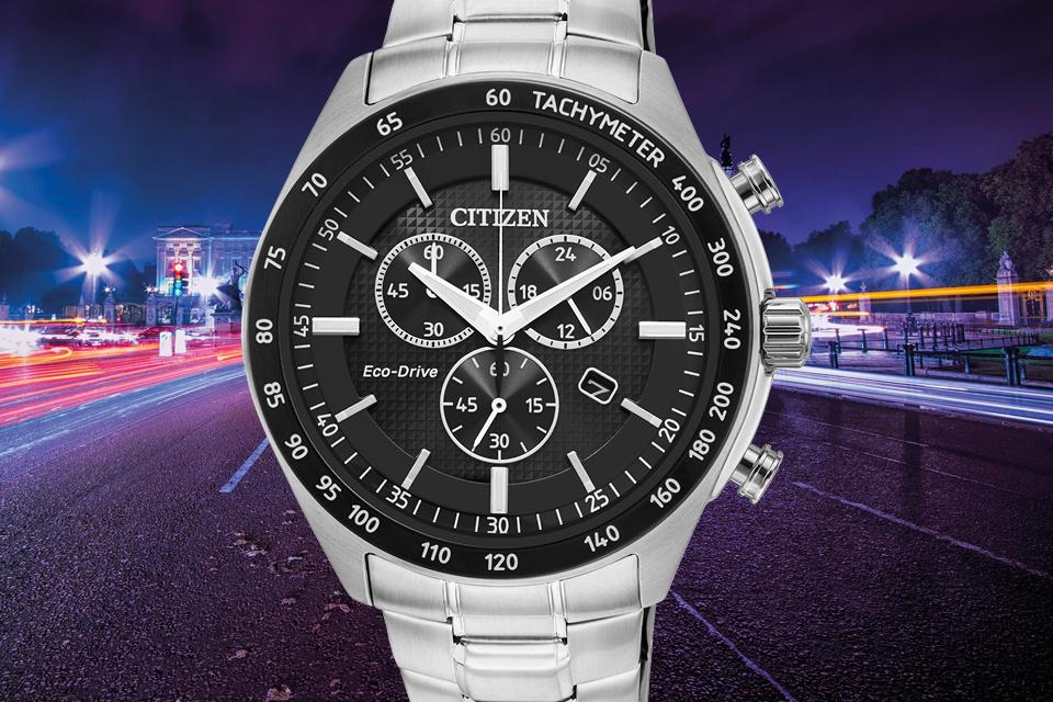 Image shows a black dial Stainless steel Citizen Chronograph watch superimposed against a streetlit road. 