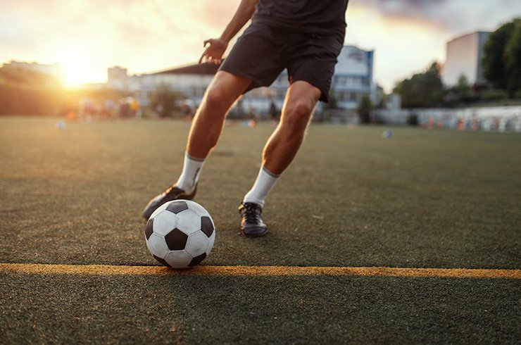 close up of a footballer and football