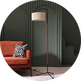 A tall slim tripod style floor lamp with a beige pleated light shade.