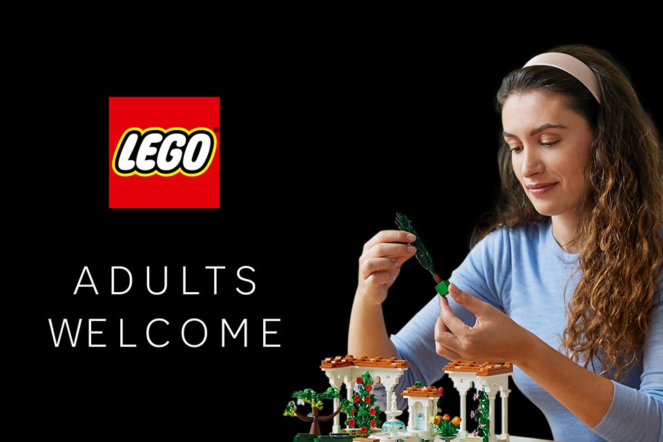 A woman playing with the LEGO® Icons Fountain Garden set against a black background. 