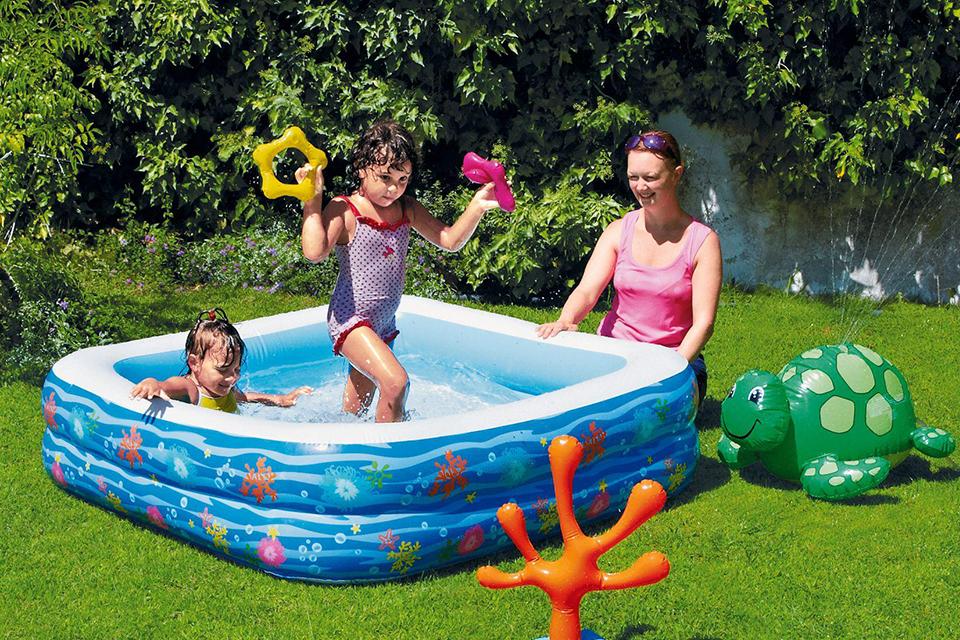 Two kids playing in the Chad Valley 5 foot paddling pool with spray turtle.