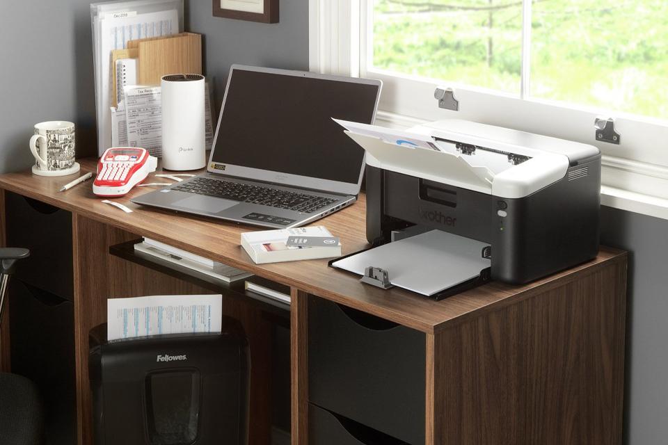 Laptop and wireless printer on desk.