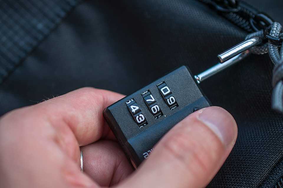 A combination travel lock attached to a luggage bag.