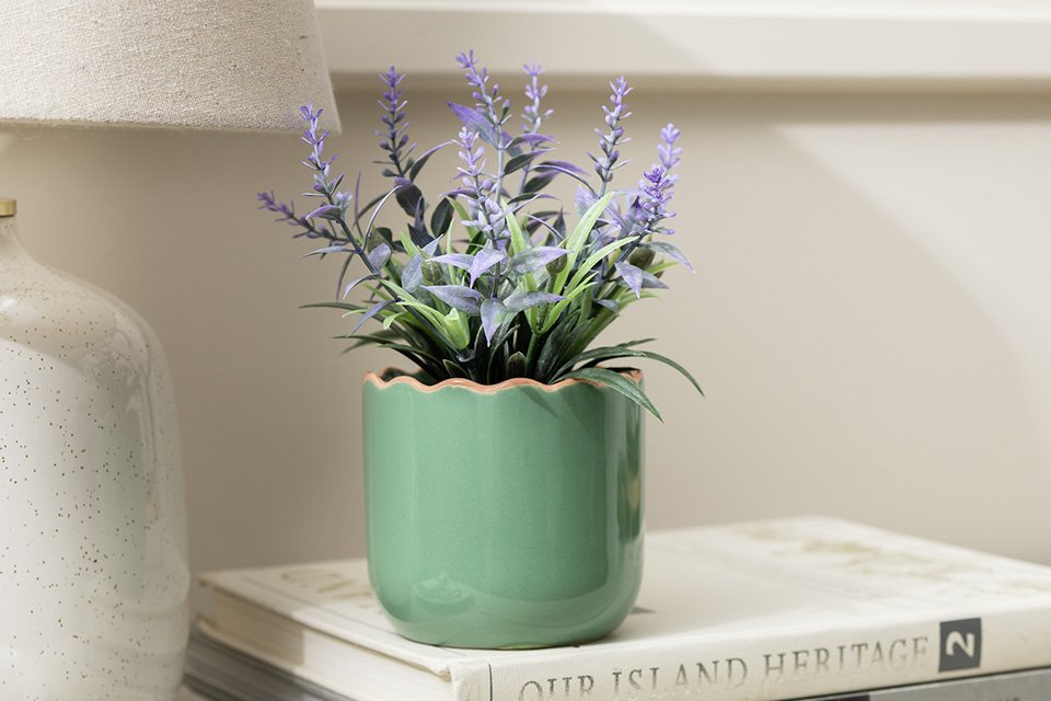 Habitat artificial lavender in Wavy green pot placed on books.