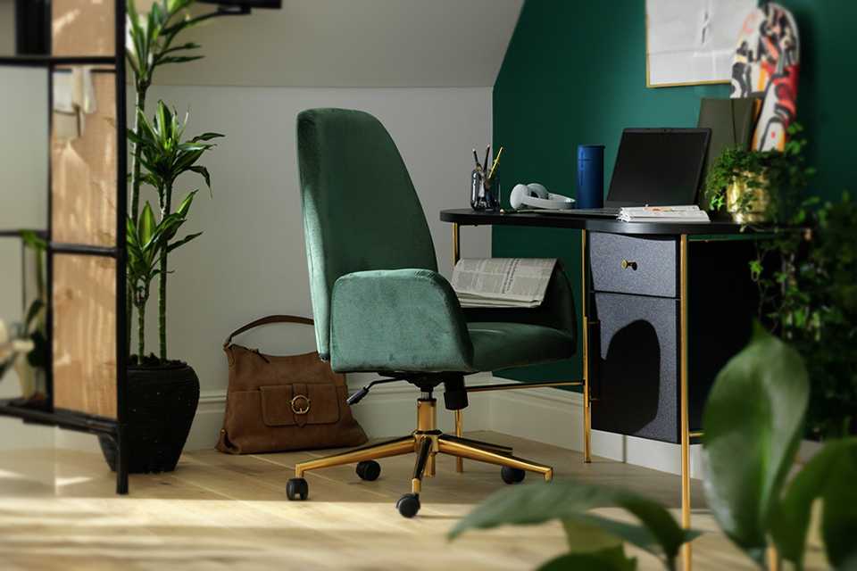 Green office chair next to black desk.