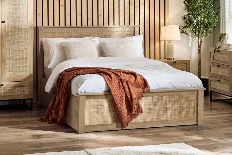 Julian Bowen Padstow Double Ottoman Bed in oak finish in a bedroom.
