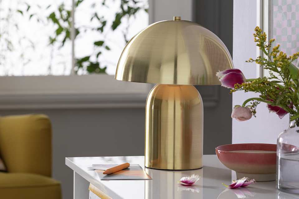 Gold mushroom lamp on cabinet in living room.