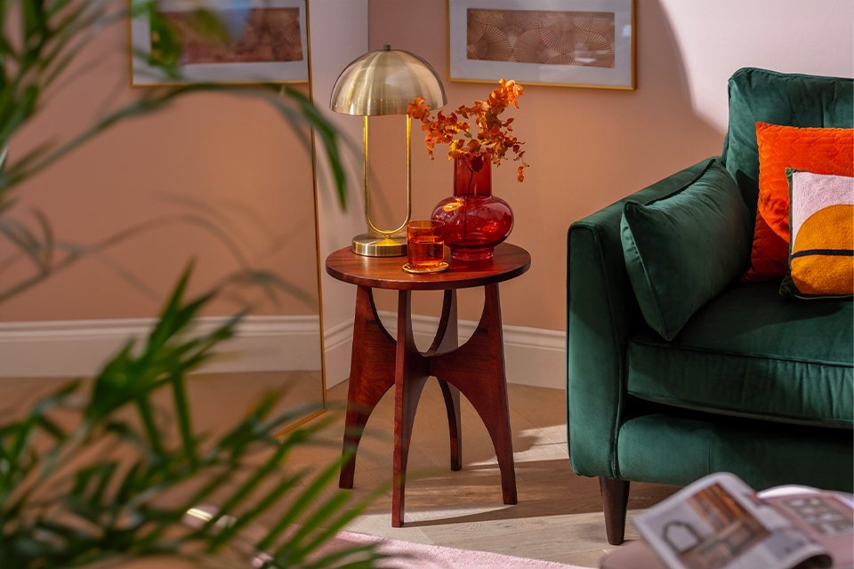 Habitat Mid Century Side Table in walnut finish placed next to a velvet green sofa.