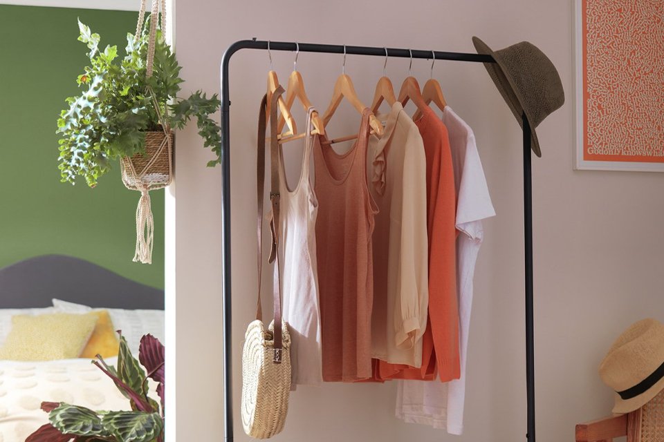 Habitat Arnie Clothes Rail in black colour placed in a hallway with clothes and a hat hung on it. 