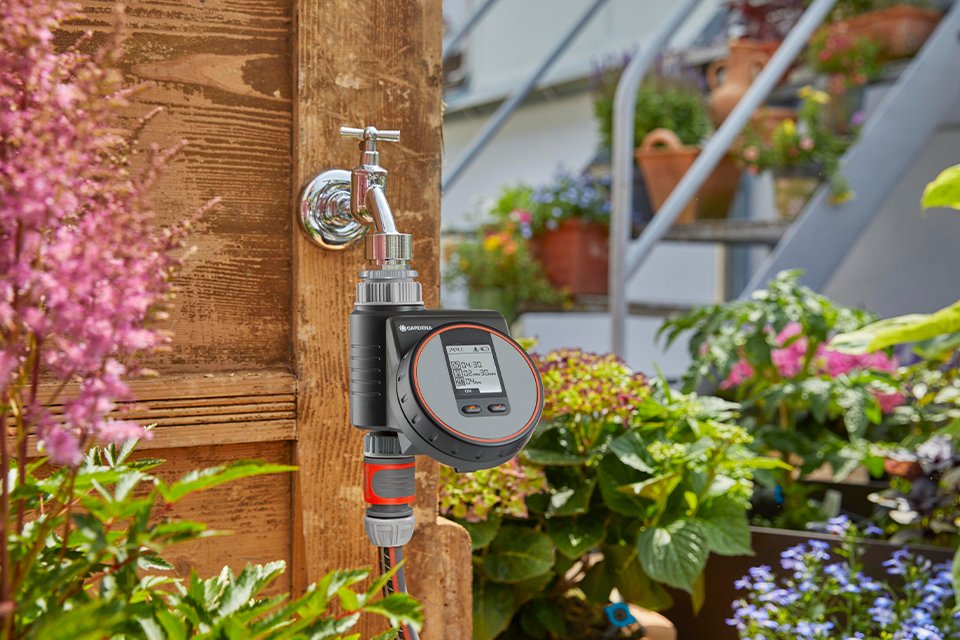 A user pressing the buttons on a Gardena Water Control Flex.