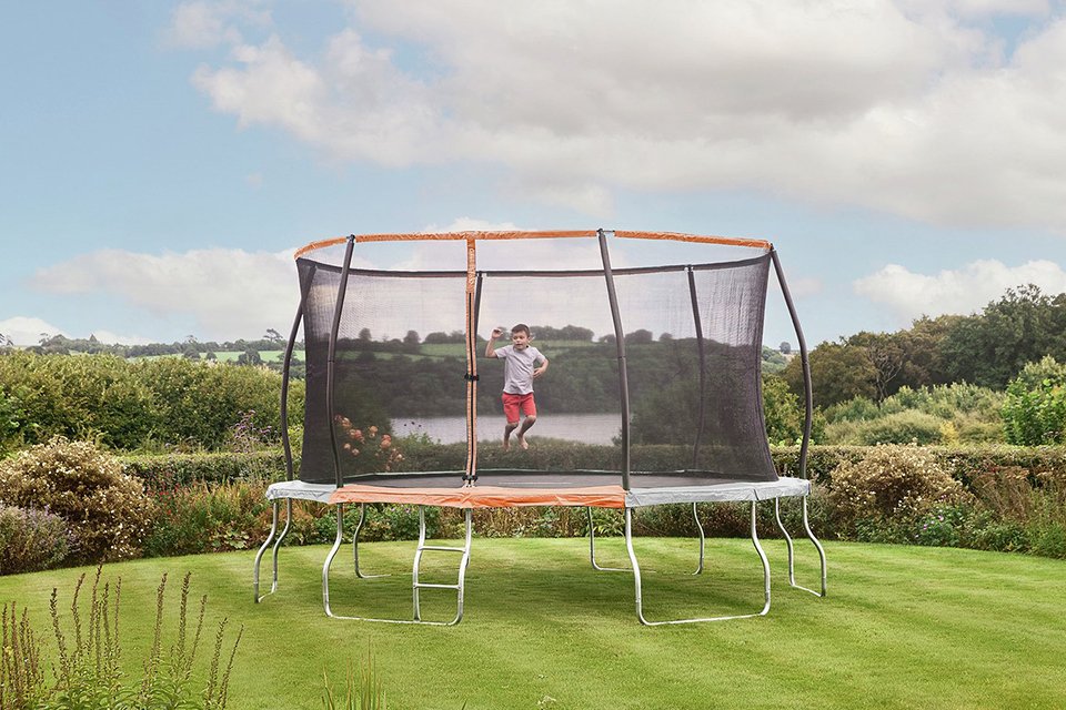 Large trampoline in a garden with a child playing
