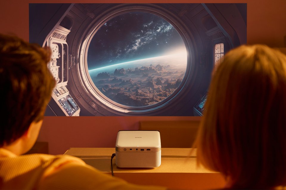 Couple watching a space movie projected on the wall.