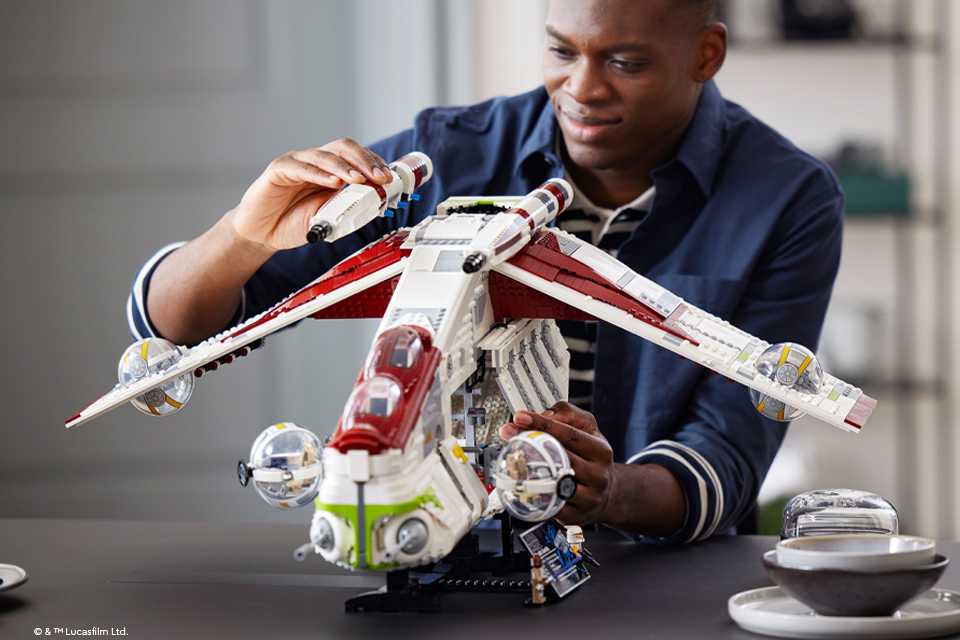 A man builds a LEGO® Star Wars republic gunship.