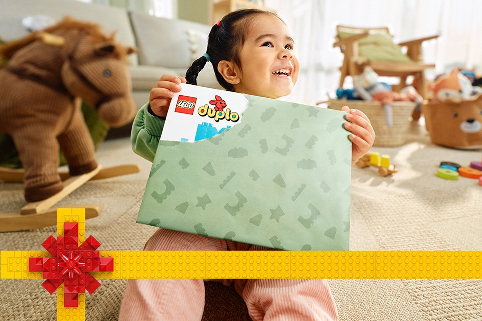 Little girl holding a LEGO® DUPLO present. 