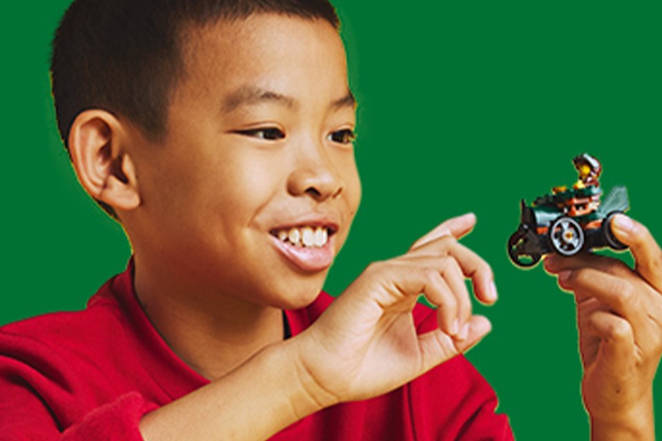 Boy playing with a LEGO® soapbox car toy.