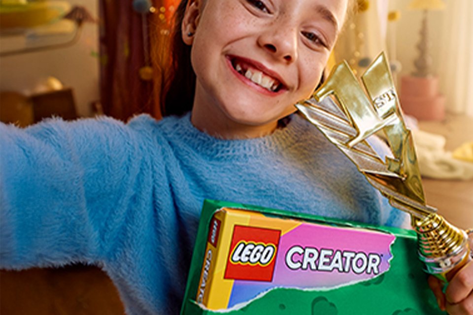 Girl opening a LEGO® Creator gift.