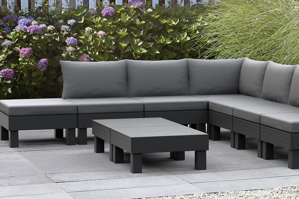 A grey Keter Elements 7 seater modular resin lounge set placed outdoors.