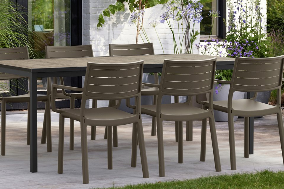 A Keter Metaline set of 6 stacking resin chairs placed around a table.
