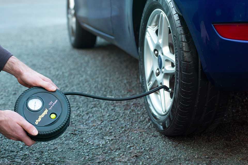 A person using a Challenge analogue tyre inflator.