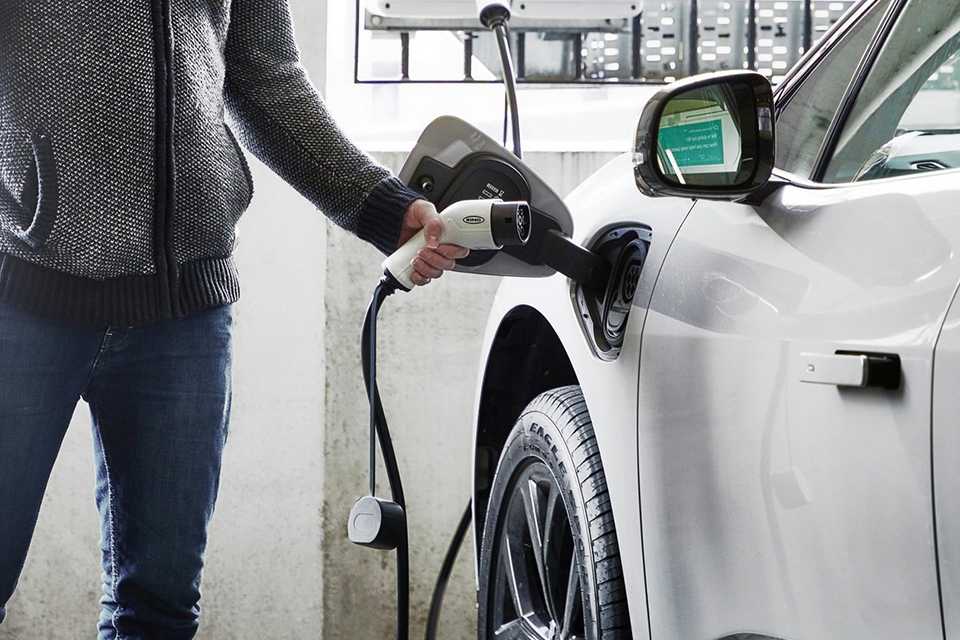 A person charging their EV using an electric charging cable.