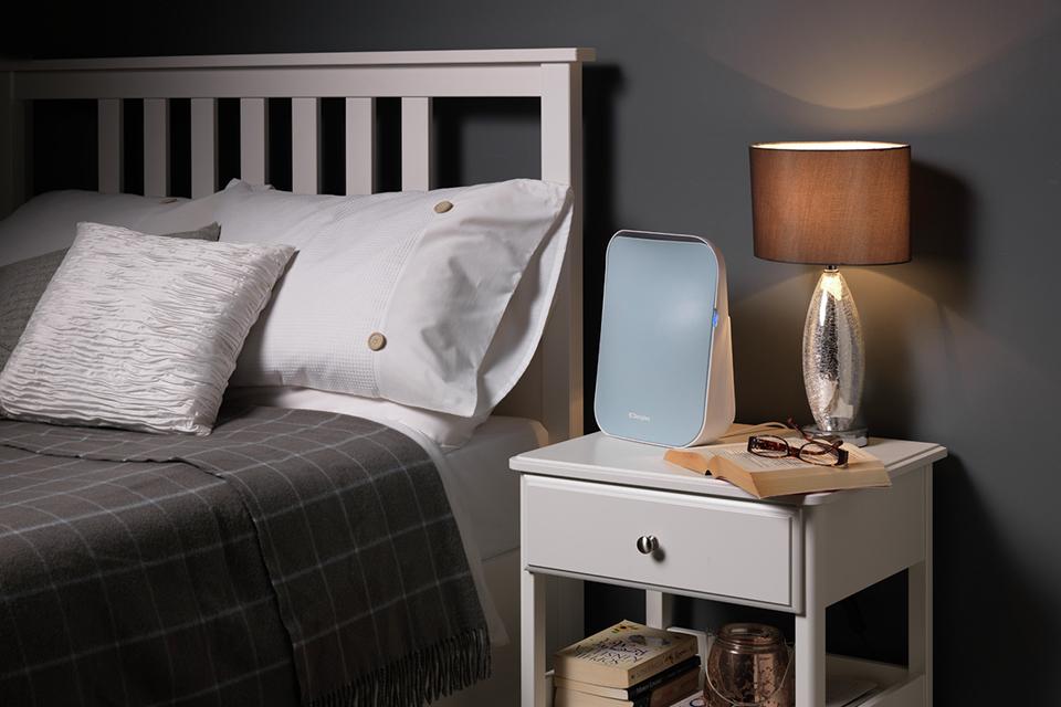 An air purifier on a bedside table.
