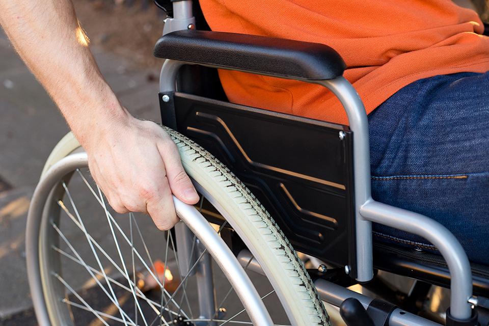 Person in wheelchair pushing wheels.