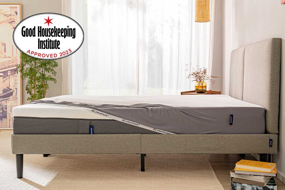 A bed with a mattress on top of it which is covered with a mattresson protector.