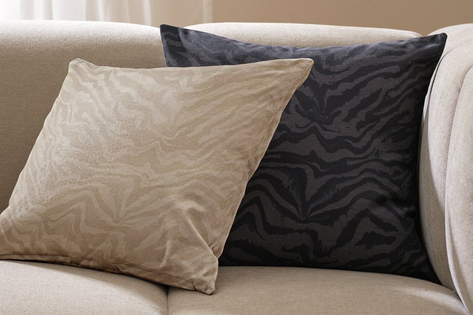 Two cushions with Habitat 2 pack Zebra print cushion covers on a white sofa.