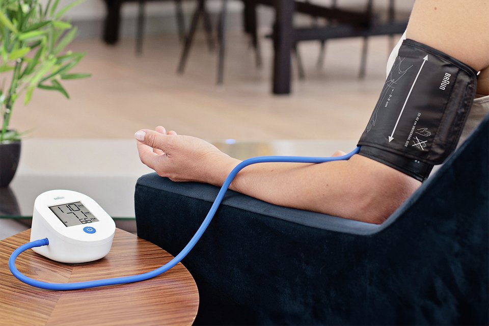 A Braun ExactFit 1E Upper Arm Blood Pressure Monitor being used to measure a person's BP.