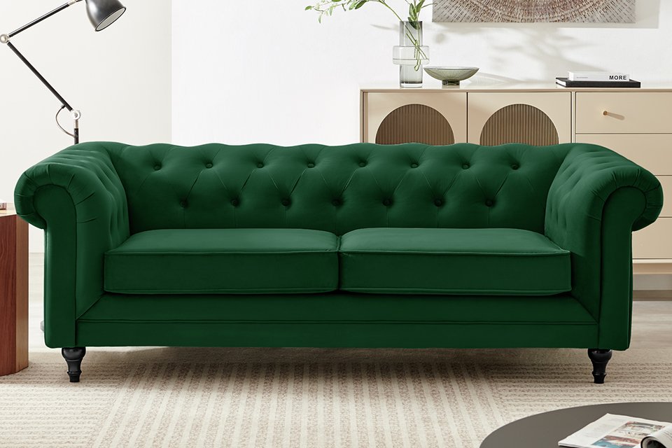 A green, velvet sofa in a living room.