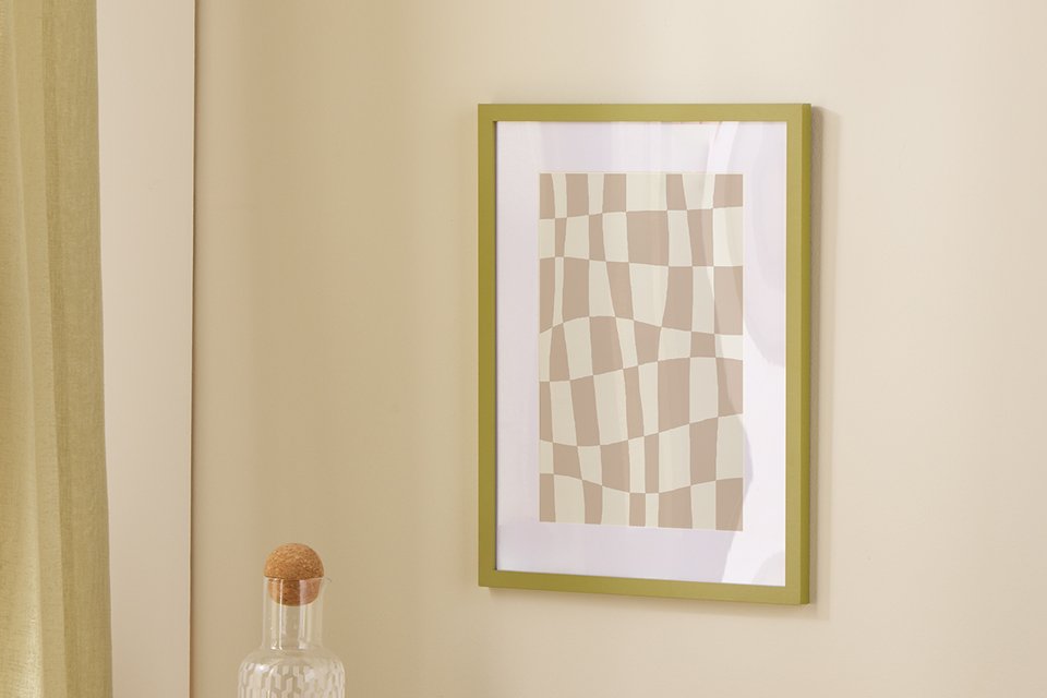 An Argos Home green Picture Frame on a wall right above the side table.