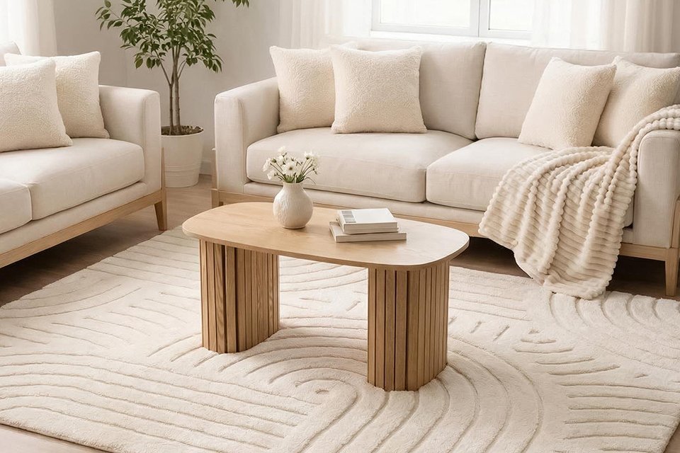 A coffee table on a contemporary tufted arches rug in a living room.