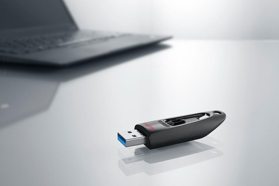 USB flash drive laying next to laptop.