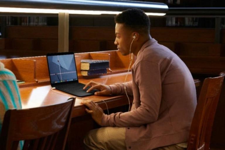 Student working in Library on laptop.