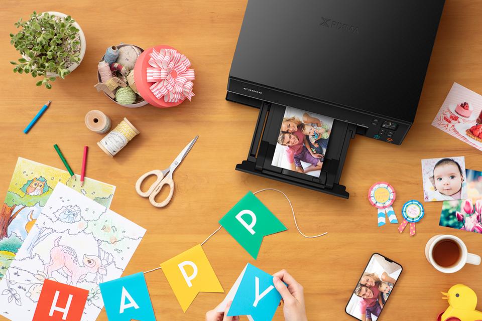 Canon Creative and Photo Printers on a desk surrounded by pictures.