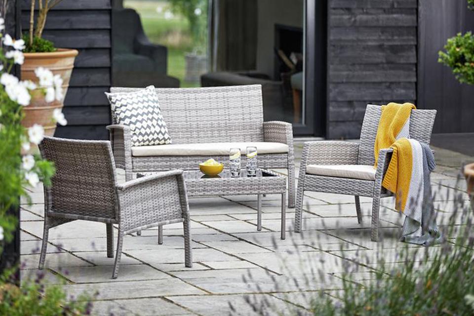 The grey Argos Home Lucia 4-seater rattan-effect sofa set in a smart garden.