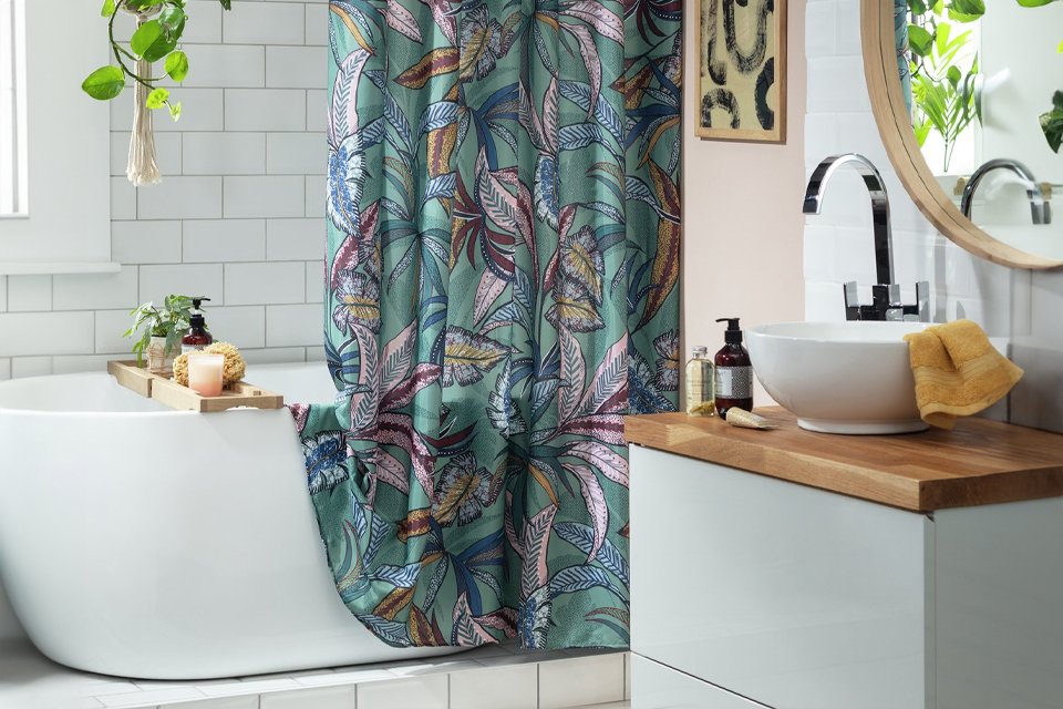 White bathroom with blue floral shower curtain.
