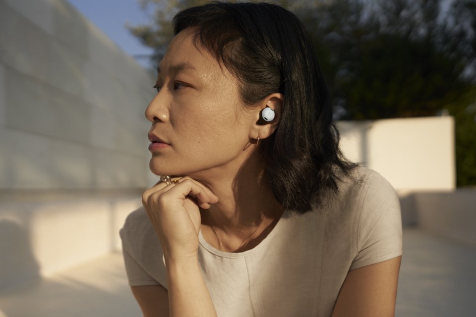 A woman wearing Google Pixel Buds Pro and looking towards her right.