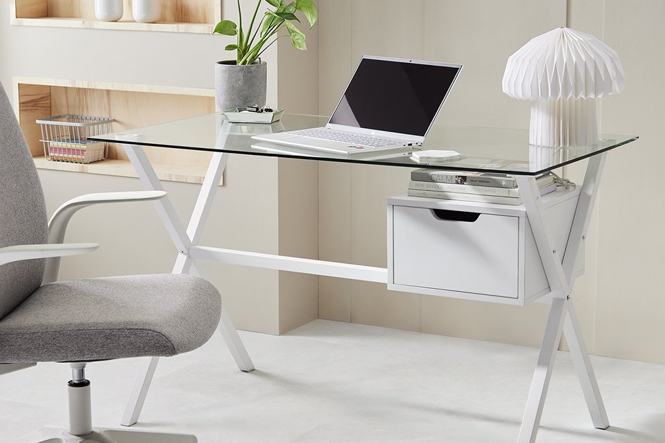A neat and minimal home office set-up with a glass table and a grey office chair.