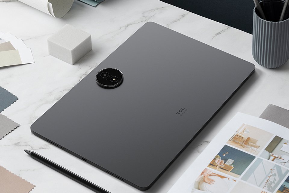 A grey TCL NXTPAPER 14 256GB Wi-Fi tablet placed on office desk with other things.