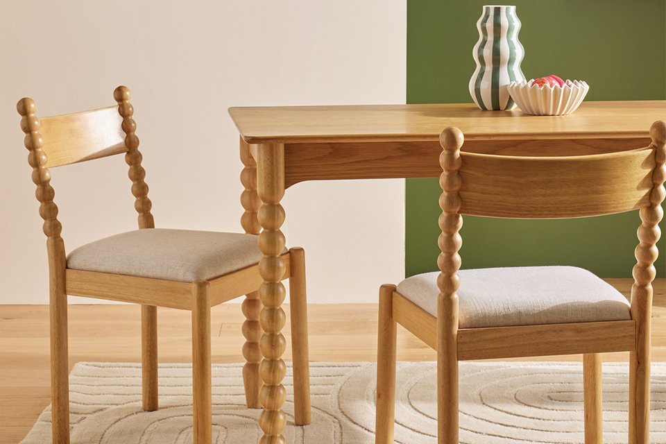 Habitat Blaire Bobbin pair of dining chairs placed with wooden dining table. 