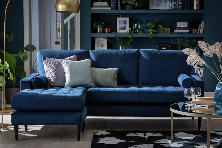 The blue Habitat Hudson reversible corner velvet sofa in a glam lounge setting.