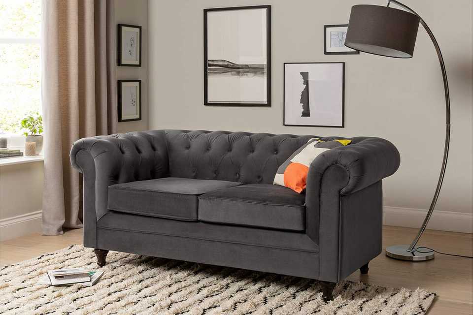 The charcoal Habitat Chesterfield 2-seater velvet sofa in a modern lounge setting.
